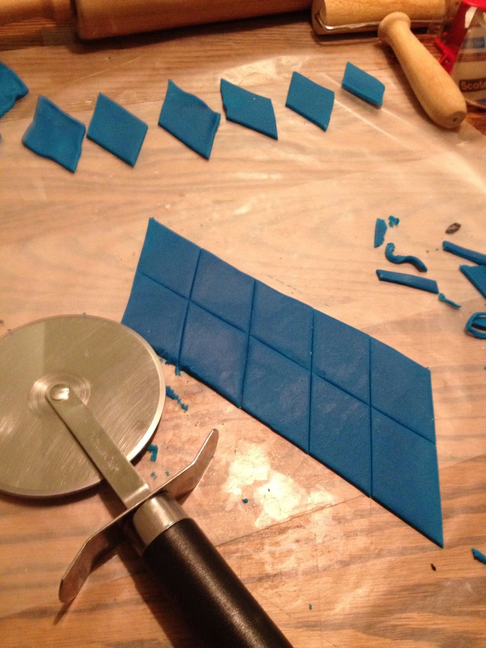 Roll out the blue fondant. Use a pizza cutter to cut it into large diamond shapes.