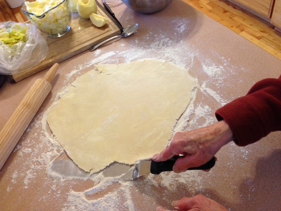 Roll out the dough evenly until its big enough for your pie pan. Use a long spatula to make sure it's not stuck to counter.
