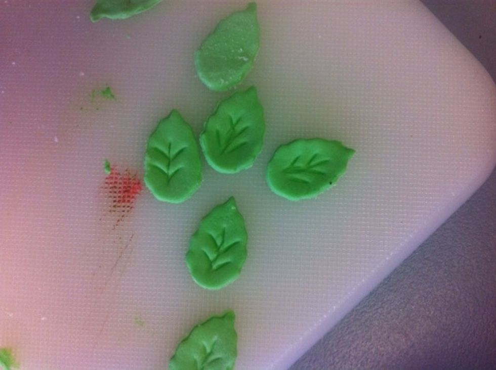 Roll out the fondant and use a leaf cutter to cut out the leaves, use a knife to make detail on them