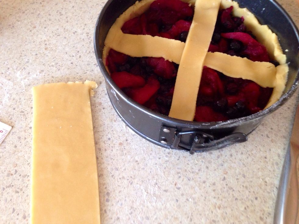 Roll out the remaining dough portion and cut into 2cm-wide strips. Arrange the strips in a lattice pattern over the filling and press to seal. Sprinkle with the demerara sugar.