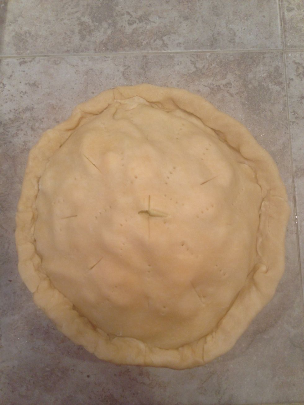 Roll out top crust and place on top of pie, pinch around edges, and poke a few holes in the top of the pie.