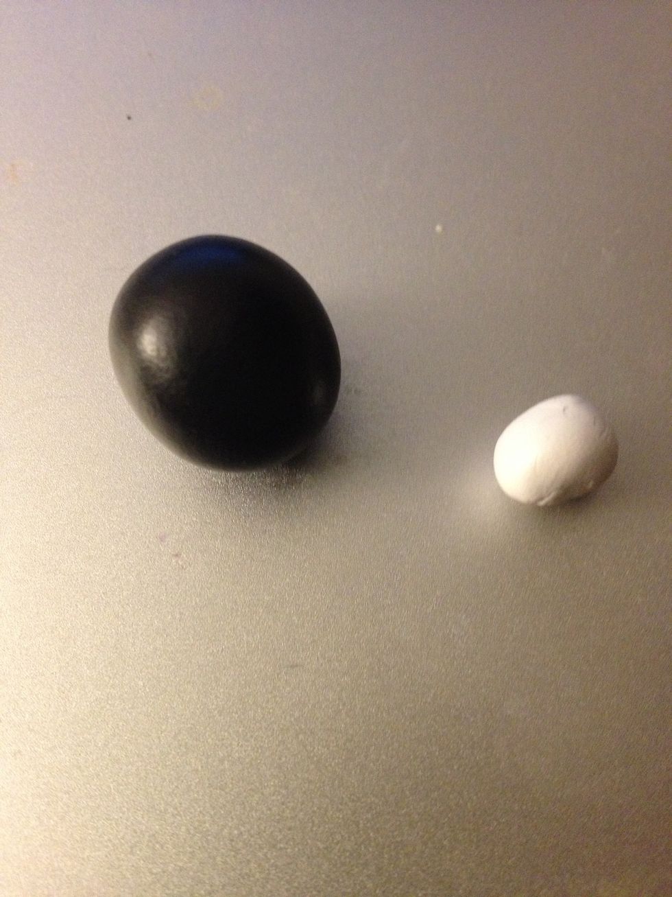 Roll out two balls of clay. A medium black one, and a small white one.