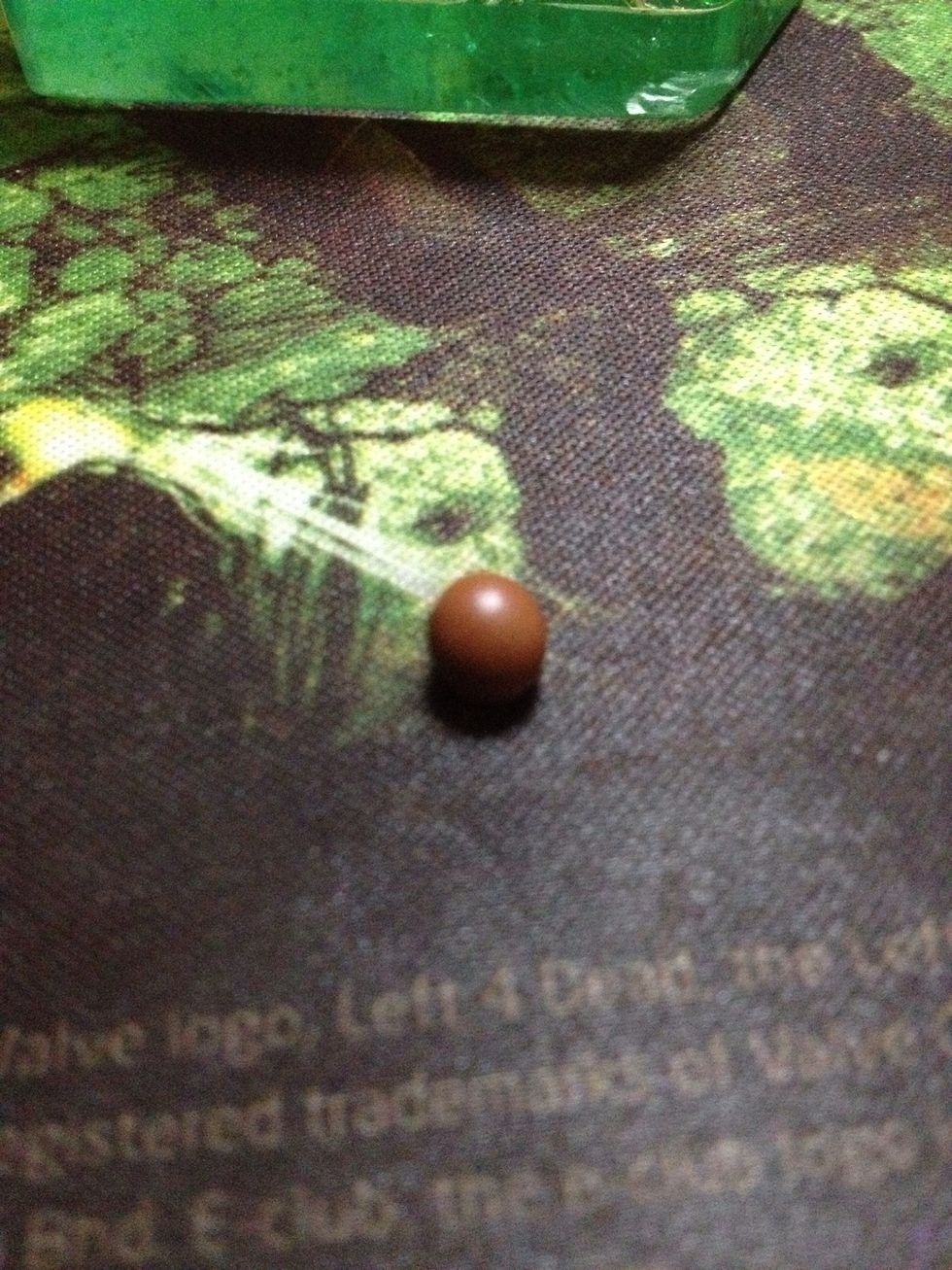 Roll the brown clay into tiny balls. These are going to be the chocolate filling of the M&Ms.