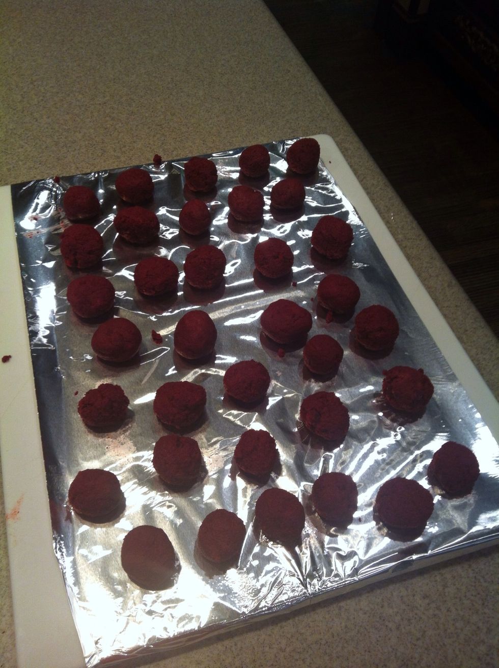 Roll the cake balls between your hands into balls about the diameter of a quarter.  As the balls get too sticky, wash and dry your hands and begin again.