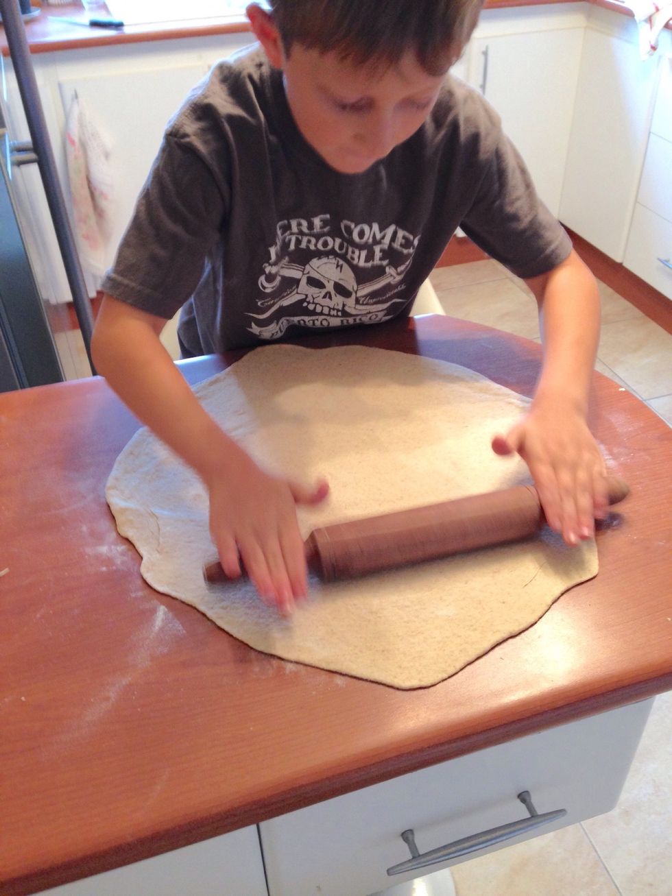 Roll the dough out to about 3 cm (1 in) larger than the pizza stone size.
