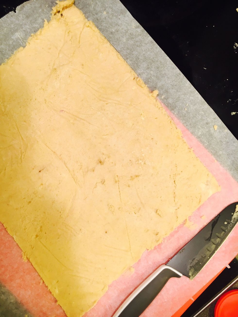 Roll the dough put on top of a flat surface with baking paper. Shape to a square.