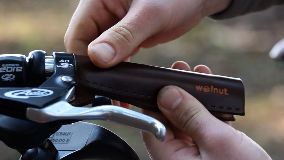 Roll the leather around the bar to form it. It should be wet and flexible.