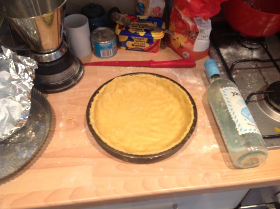 Roll the pastry out and lay over a tart dish and smooth into the shape, then cut off the excess at the top