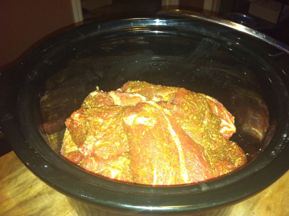 Roll the pieces of pork in the garlic first then roll in the spice mix, place them in the crock over the cilantro and bay leaves.