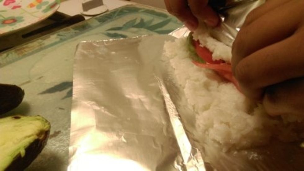 roll the sushi, and tuck in the filling. fold again to secure it.