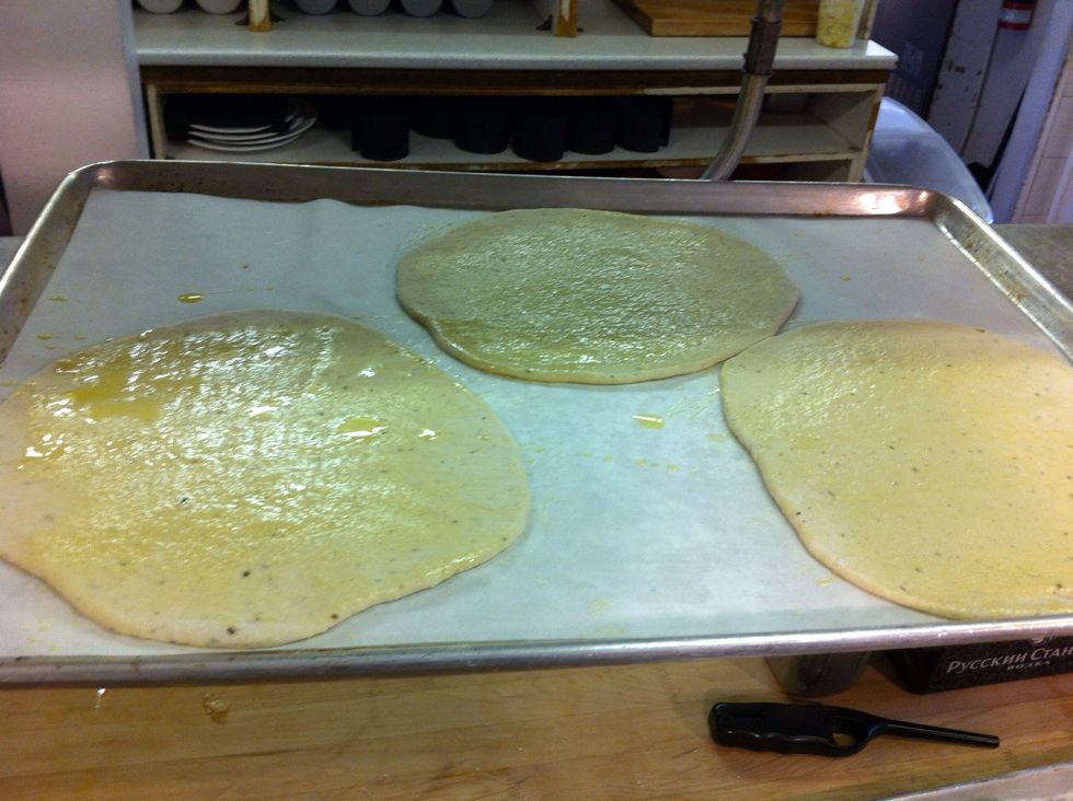 Roll them out a little smaller than a dinner plate I never worry about them being perfectly round, or round at all really. It's more " rustic" this way. Oil the tops and cover with parchment. Repeat.