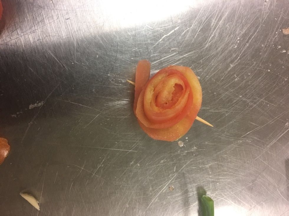 Roll tomato skin and pin with a toothpick to keep in position