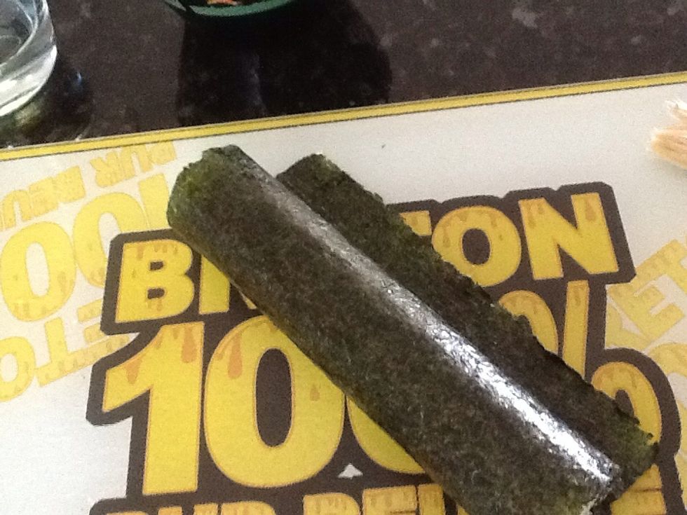 Roll up sushi in seaweed. To close the little flap bit of seaweed, use your other bowl if water and with either fingers or and egg brush, run water along the edge, then press into roll to close sushi.