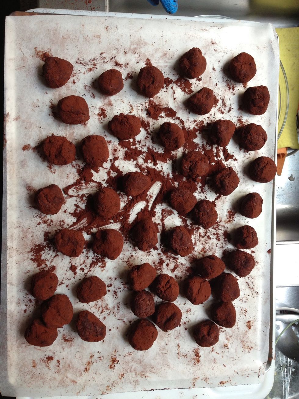 Roll vaguely one by one using the extra cacao on the parchment paper.