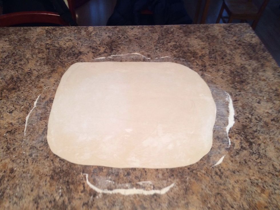 Roll your dough, you don't have to be specific as to the size or shape. But try to keep it as wide as your baking sheet so it fits.