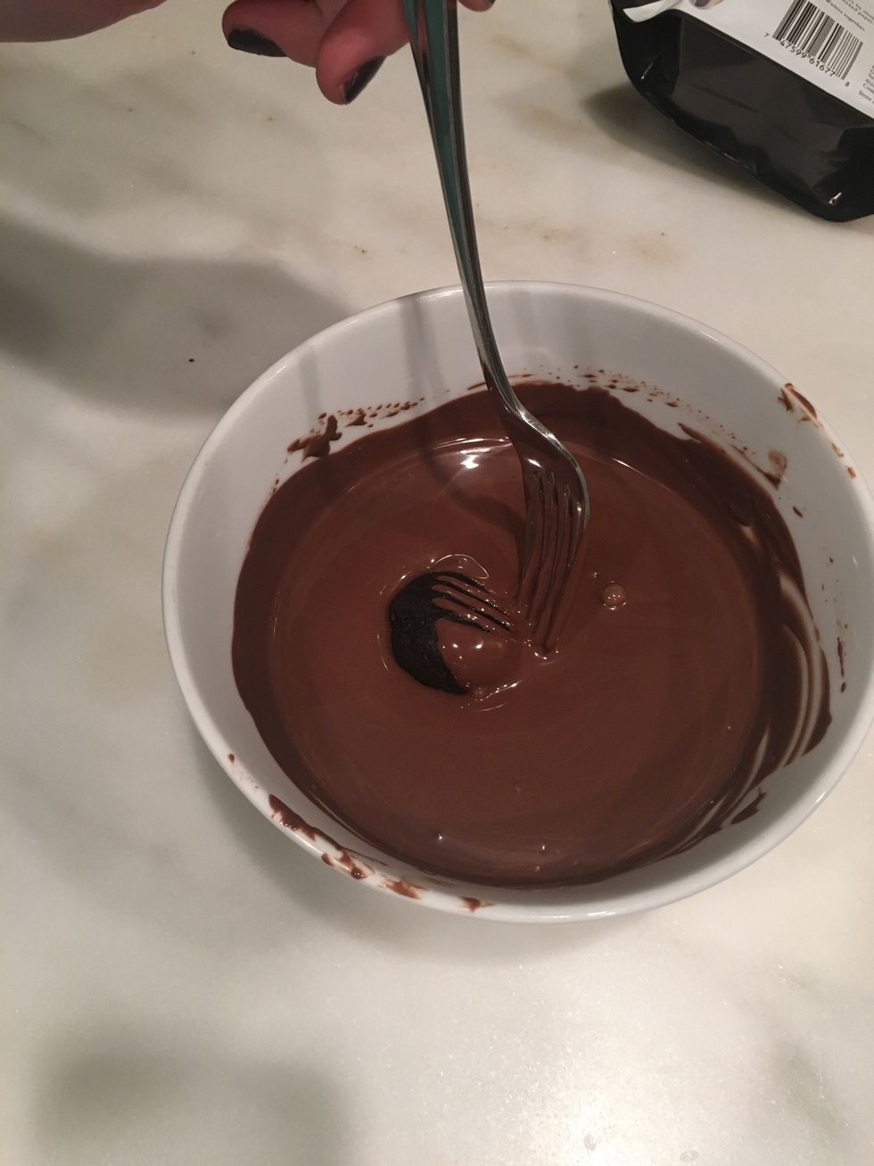 Roll your oreo balls in the chocolate, completely covering them.