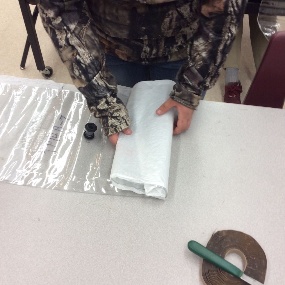 Rolling the bag and the tissue up with the bag so I don't ruin the long bored when I set the n Long bored up.