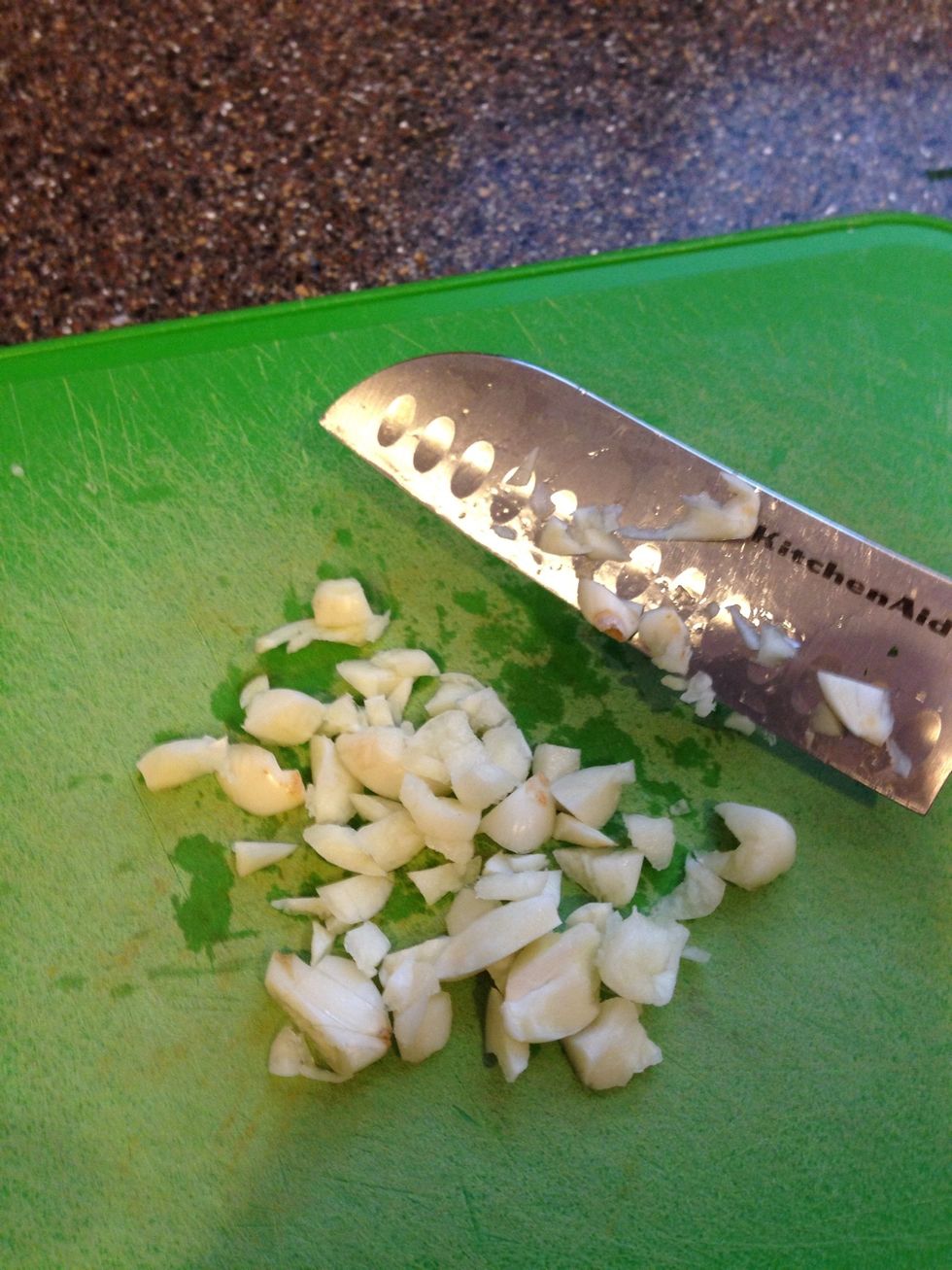 Rough chop on 4-6 cloves. TIP: crush each clove with your palm to make it easier to peel the skin off.