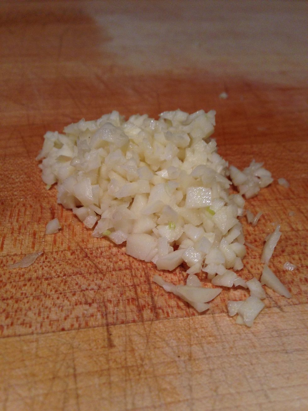 Roughly mince three cloves of garlic.