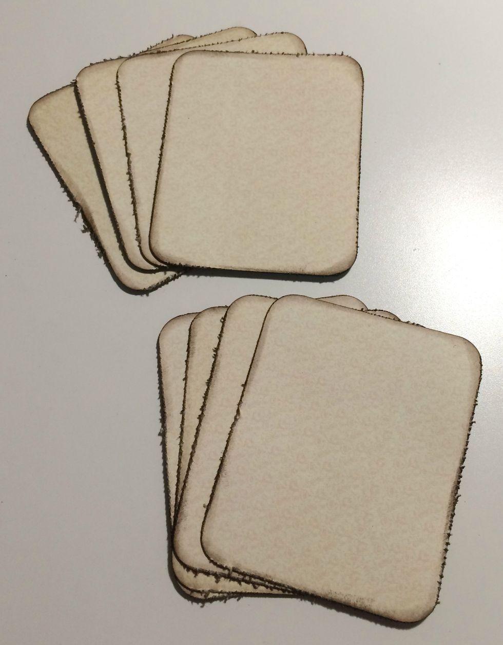 Round all four corners of the cream pieces. Once the corners have been rounded, edge distress them. With a blending tool ink the edges of the paper using Walnut Stain Distress Ink.