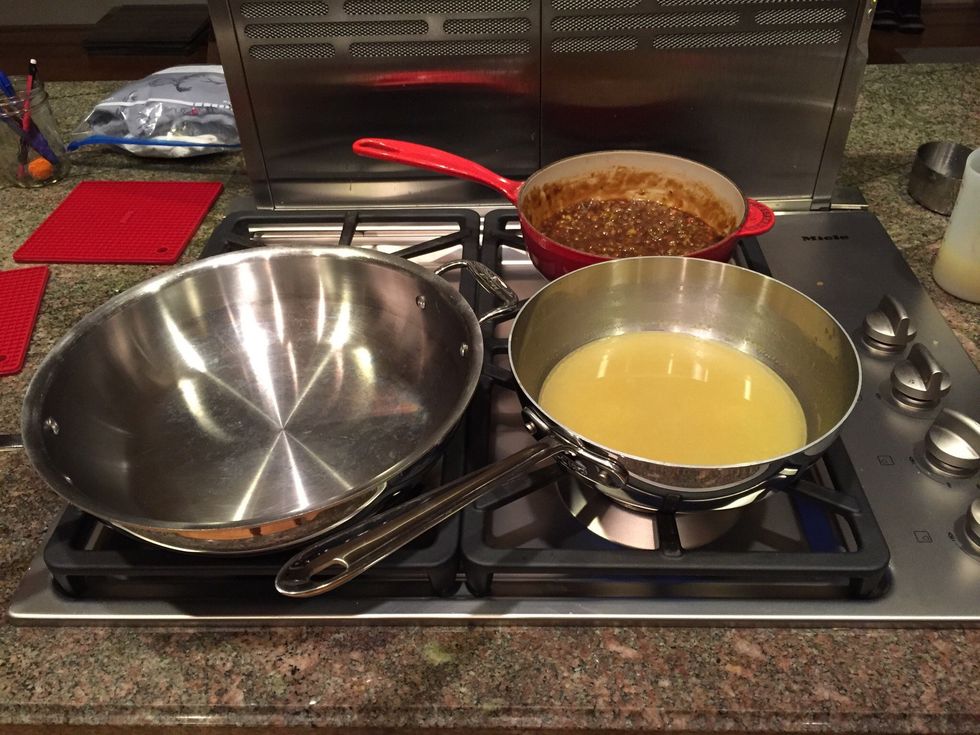 Roux, off heat, chicken broth, and large pot for cooking butter, green onions, and crawfish meat