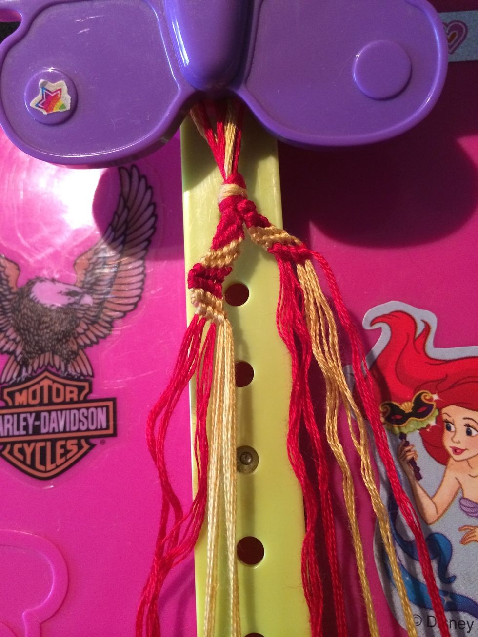 Row 3 is done. Can you guess what theme this bracelet is going to be? Grab the red string and start working on the next row.