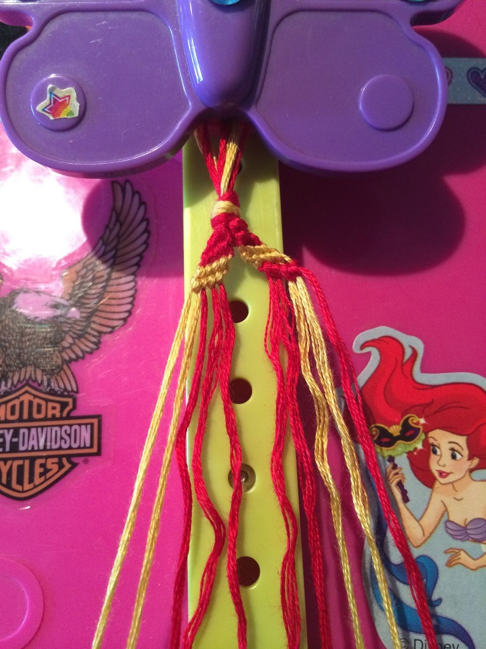 Row four is done. Time to do the fifth row. Go ahead and grab that last red string and make your way across the others.