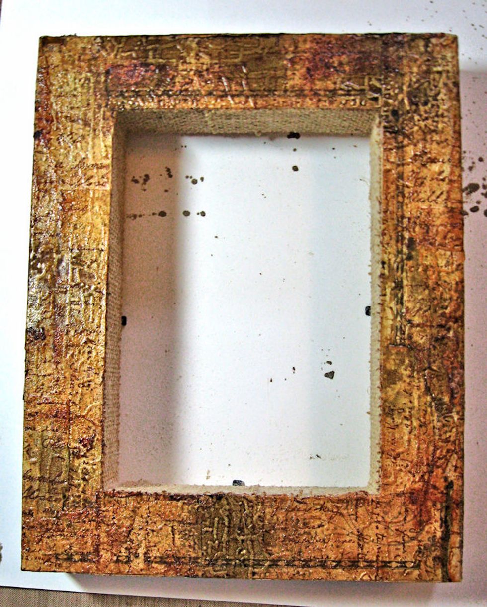 Rub edges of frame with Rusty Hinge DI. Spritz with Eucalyptus Walnut Ink. Heat dry a little. Sprinkle with clear embossing powder and heat set to seal the inks.