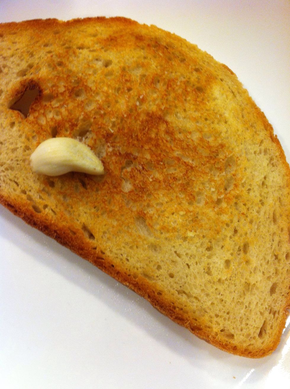 Rub garlic clove on the toasted bread.