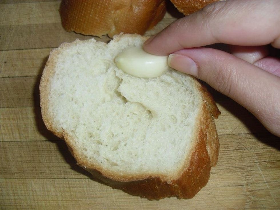 Rub the bread with the garlic slice .