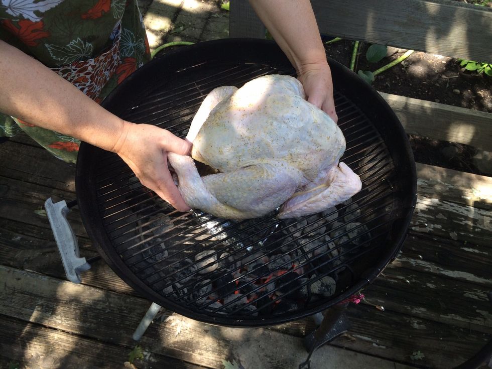 Rub the outside with the baste and place the bird on a preheated charcoal grill.