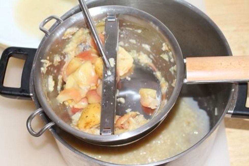 Run apples and pears through a food mill (as shown) in order to separate the sauce from the skins. No food mill? You can run your peeled fruit through a blender or have at it with a potato masher.