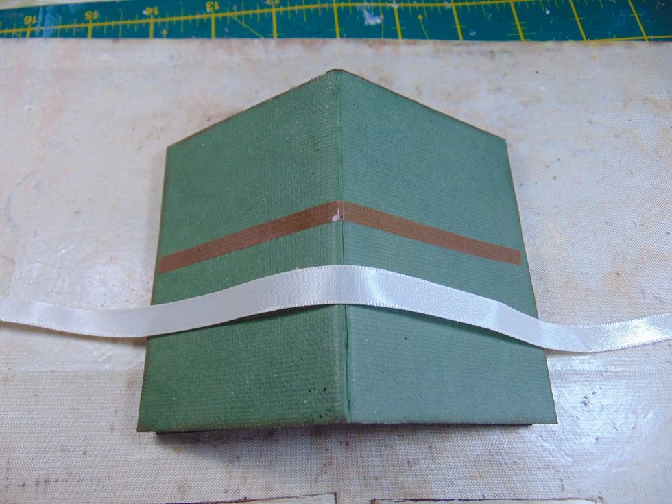 Run some strong red tape across the centre of the album front and back. Adhere some ribbon to the tape, leaving plenty of excess at each end for tying later.