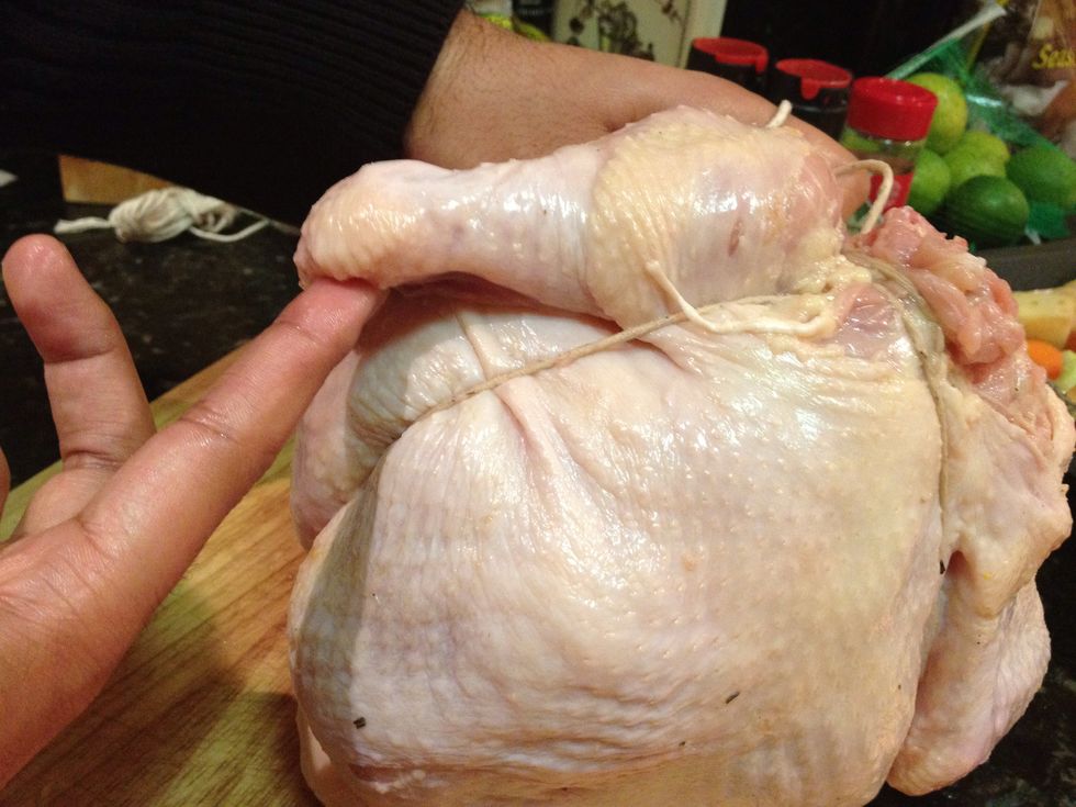 Run the twine towards the front of the chicken and underneath the wings.