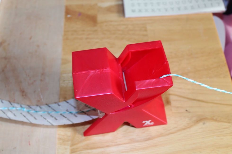 Run twine through 1.5" Xyron sticker maker.