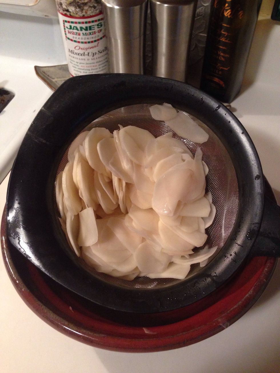 Run your fingers through the potato slices to help get the last bit of water out. I just put my strainer back in the empty bowl and do it over the bowl.