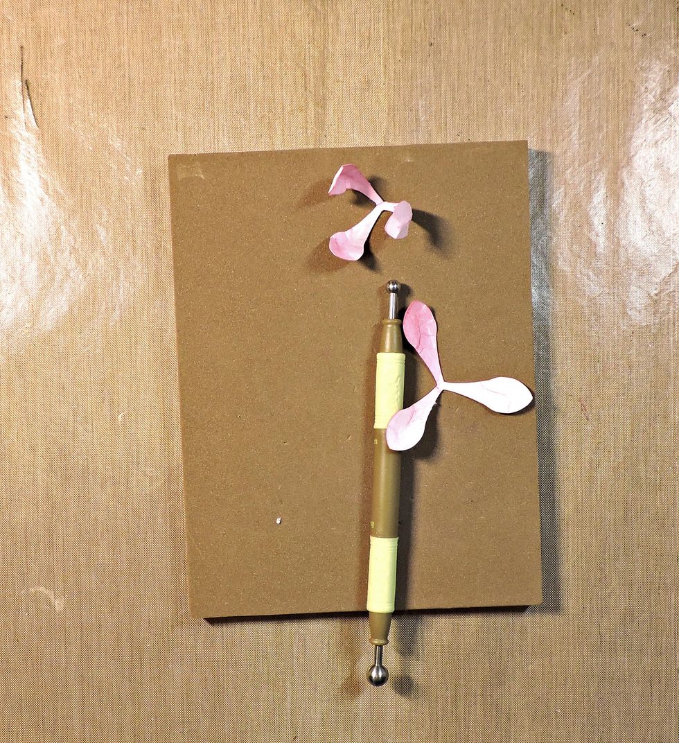 Run your shaping tool down each petal, from the tip to the center. It helps to use a foam pad underneath. (Tip: the round end of a ball point pen on your hand will work if you don't have these tools.)