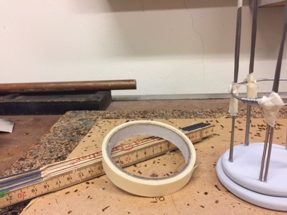 S\u00e4tt ringen runt pinnarna och tejpa fast den med maskeringstejp 6 cm upp.