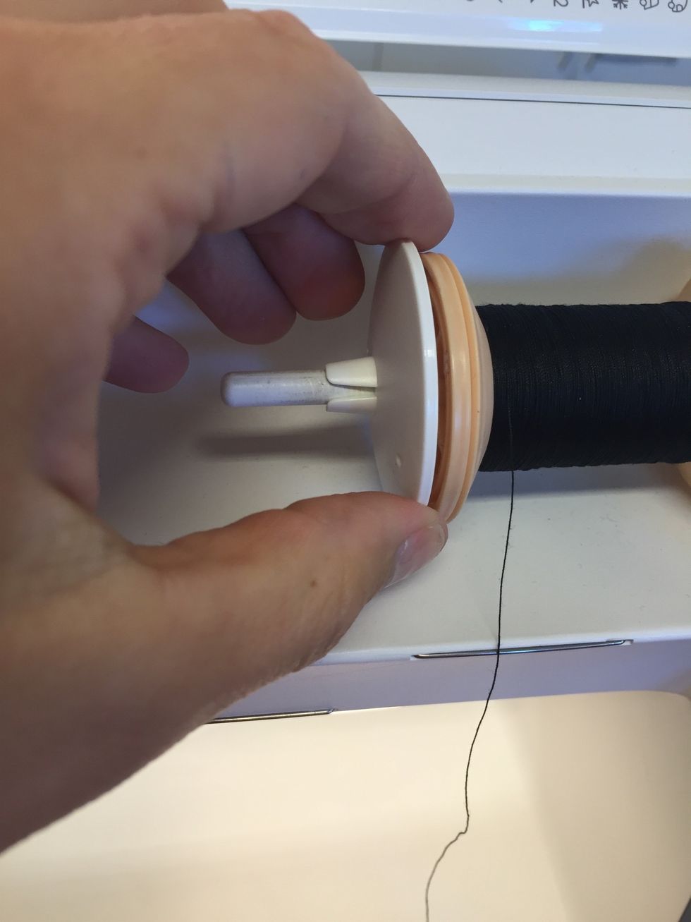 S\u00e4tt tillbaka brickan igen, s\u00e5 att tr\u00e5drullen h\u00e5lls p\u00e5 plats.