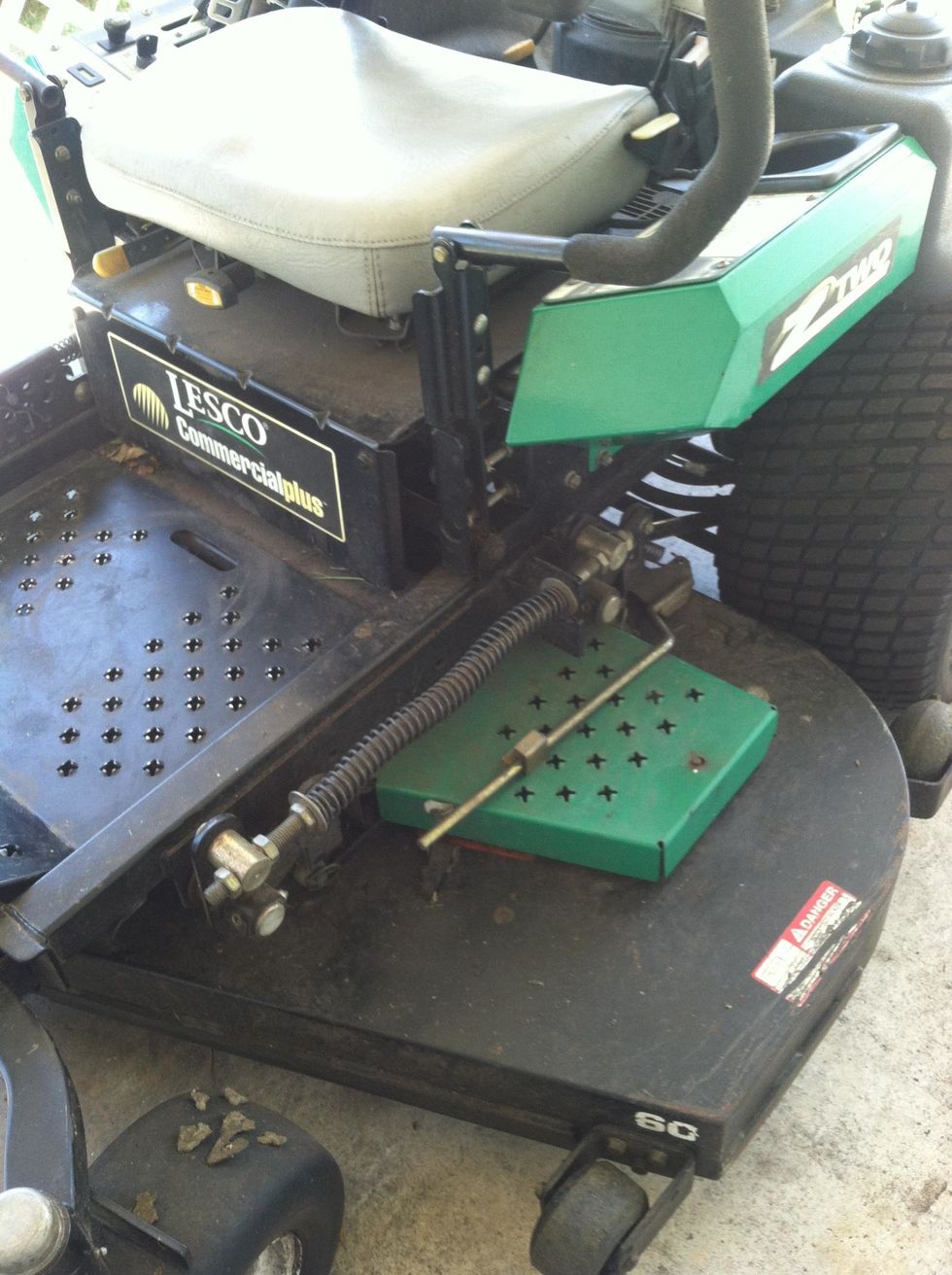 safety covering on the other side. On this particular machine, note the spring loaded bar being held by the metal clip, that is the belt tensioner for the blade belt, it needs to be released.