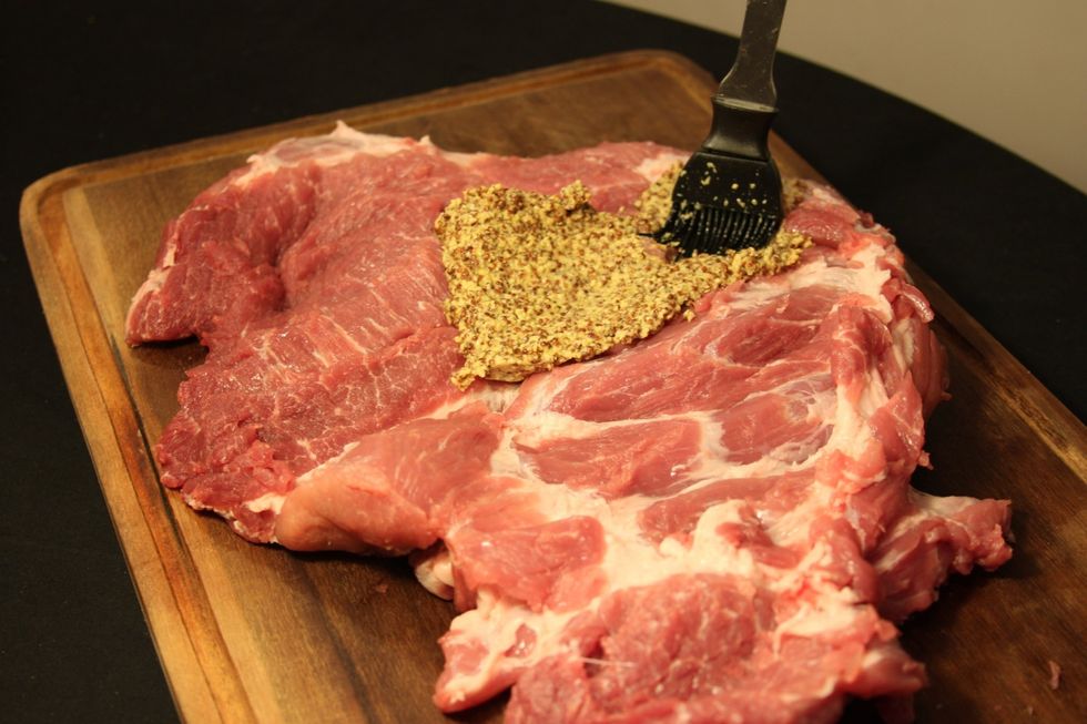 Salgar a carne a gosto. Logo, espalhe a mostarda de dijon \u00e0 antiga  sobre a superficie.