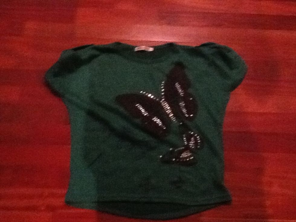 Samarreta verda amb uns dibuixos curta Es pot portar amb malles negres i pantalons curts o amb texans