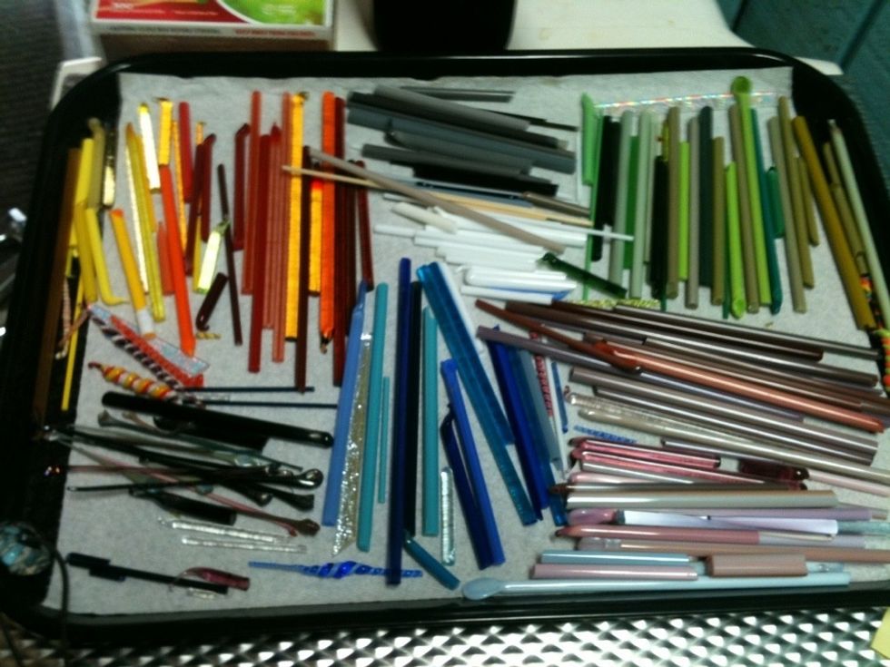 Sample of glass rods, "dichro" strips (iridescent glass), twisties (multiple colors twisted together into rods) & stringers (thin rods). These are working bits, when purchased they are 14" long.