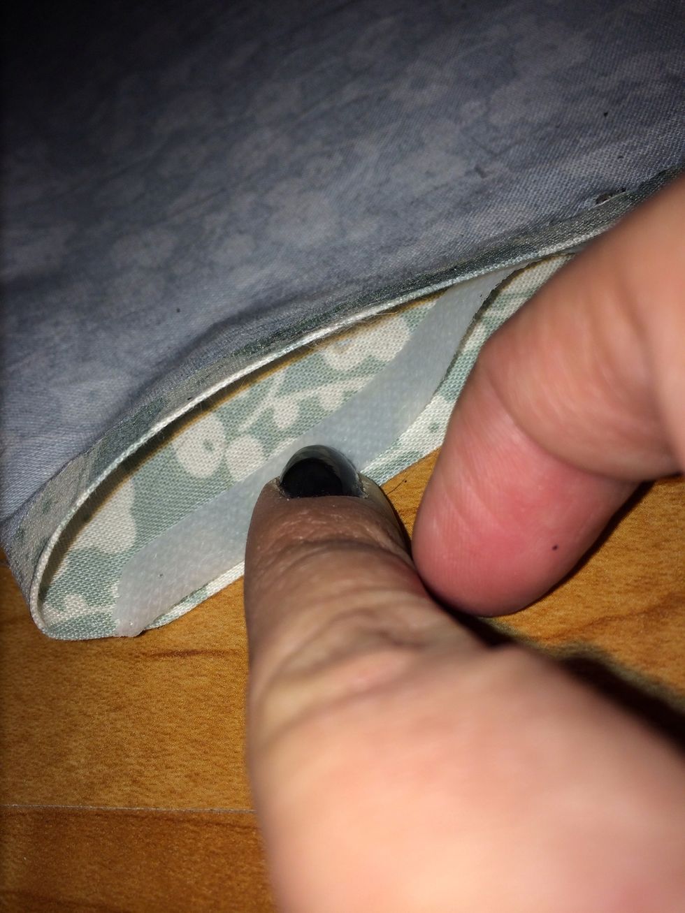 Sandwich adhesive tape between fabric edges.