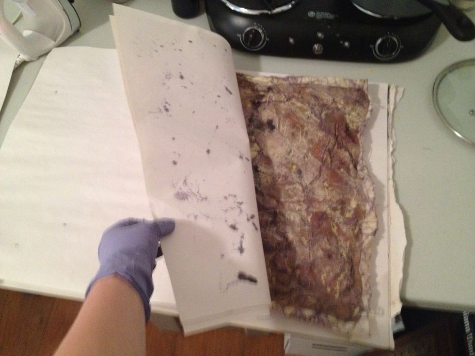 Sandwich art between a couple loose sheets of newsprint and turn on your iron. You will put the iron on the top pieces of paper to melt the remaining wax.