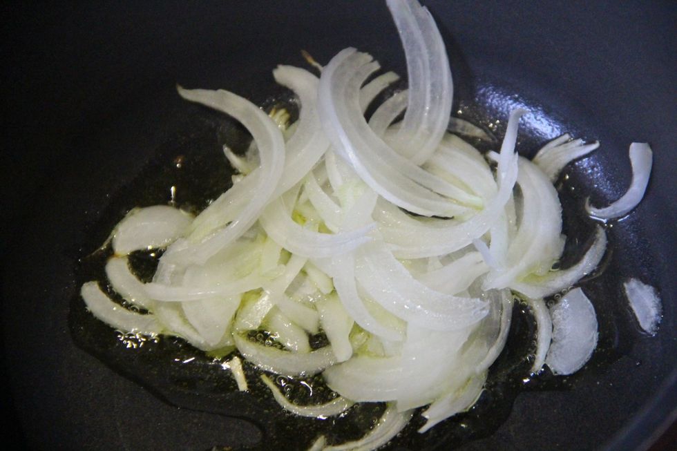 Saut\u00e9 chopped white onions in pan with olive oil