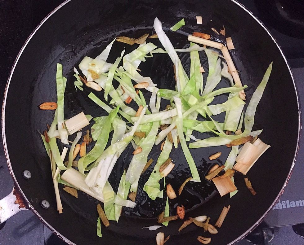 Saut\u00e9 ginger and garlic. Add cabbage and lemon grass.