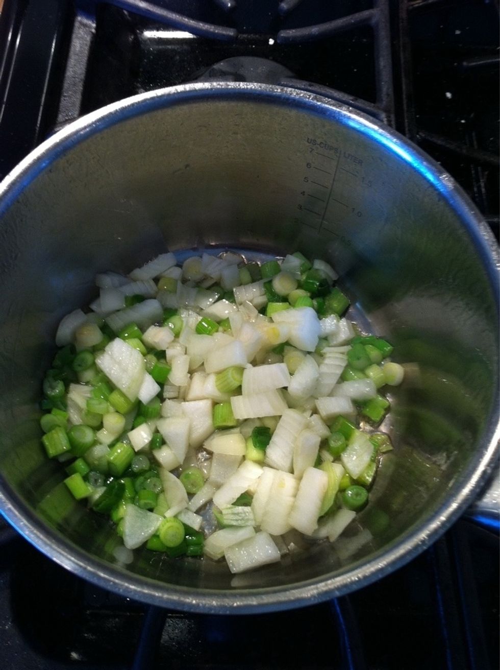 Saut\u00e9 onions and spring onions in olive oil for about 3 mins or until wilted