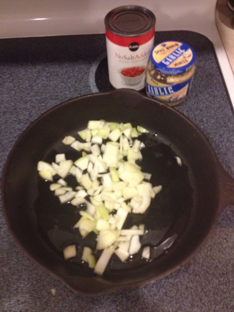 Saut\u00e9 onions in olive oil in a cast iron skillet until translucent