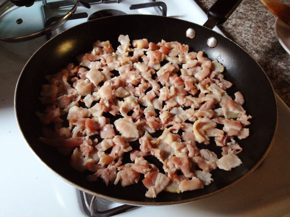 Saut\u00e9 the bacon in a flat pan over medium-high heat until slightly browned.